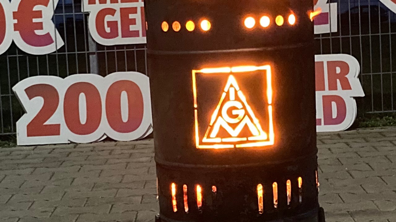 Feuertonne vor Plakaten - es ist Nacht